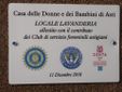 La targa apposta all’ingresso del locale lavanderia alla Casa delle Donne e dei Bambini di Viale al Pilone.
