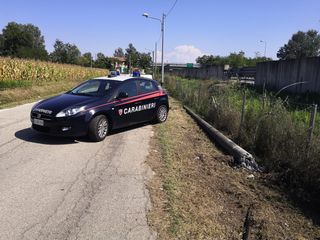 Una pattuglia dell'Arma sul luogo del sinistro, dove ancora si nota il palo abbattuto dall'auto