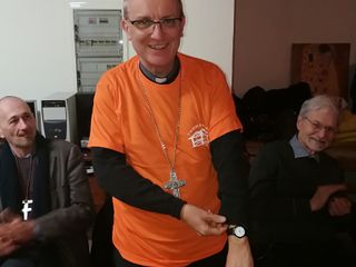 Il vescovo di Asti con la maglietta dei volontari dell'associazione Il vescovo di Asti con la maglietta dei volontari dell'associazione