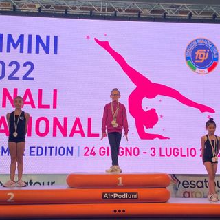 La giovanissima atleta sul gradino più alto del podio e, a fine articolo, ritratta con le tre medaglie vinte