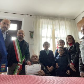 Il neo centenario ritratto con il presidente della Provincia, il sindaco di Portacomaro e i suoi familiari