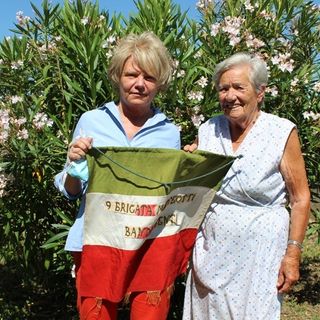 Giovanna Beccuti e Maria Pia Panattero con la bandiera della 9ª Brigata Matteotti