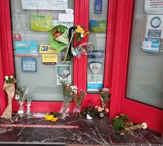 Mazzi di fiori lasciati davanti alla tabaccheria che il giovane aveva gestito a lungo