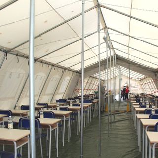 L'interno della tensostruttura e bambini in fila indiana all'ingresso