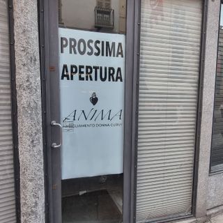 Cartello di prossima apertura di un negozio di abbigliamento in via Cavour