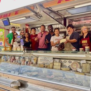 Turisti americani dietro al bancone di Michele al mercato di Buttigliera d'Asti