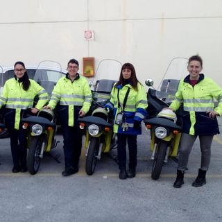 Le postine di Poste Italiane in divisa davanti ai motorini