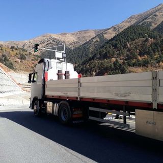Un mezzo di trasporto percorre la strada di un colle di montagna