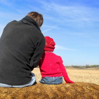 Padre con bambino su una balla di fieno