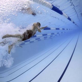 uomo in piscina mentre nuota
