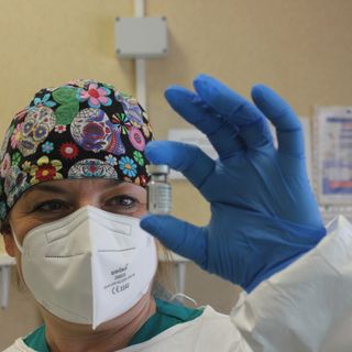 Un'infermiera con una fiala di vaccino Pfizer