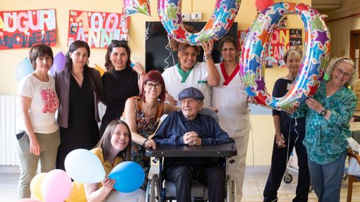 Il neo centenario circondato da parenti e personale della struttura assistenziale
