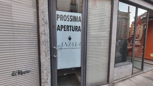 Cartello di prossima apertura di un negozio di abbigliamento in via Cavour