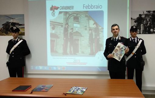 Il comandante Breda con il calendario 2019 e, sullo sfondo, la proiezione dello scatto inserito nella versione da tavolo