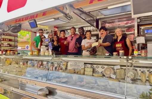 Turisti americani dietro al bancone di Michele al mercato di Buttigliera d'Asti