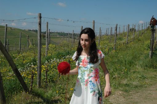 La giovane attrice Alice Borghetto con il gomitolo di lana rossa che scandisce il racconto La giovane attrice Alice Borghetto con il gomitolo di lana rossa che scandisce il racconto