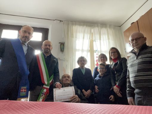 Il neo centenario ritratto con il presidente della Provincia, il sindaco di Portacomaro e i suoi familiari