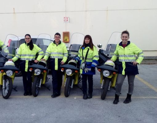 Le postine di Poste Italiane in divisa davanti ai motorini Le postine di Poste Italiane in divisa davanti ai motorini