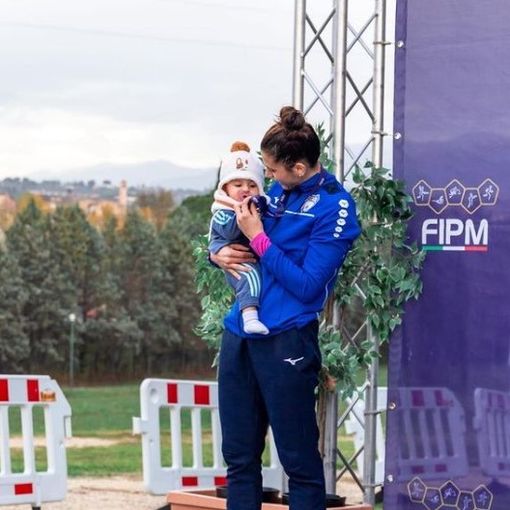 Immagine d'archivio dell'atleta sul podio con la figlia, all'epoca neonata