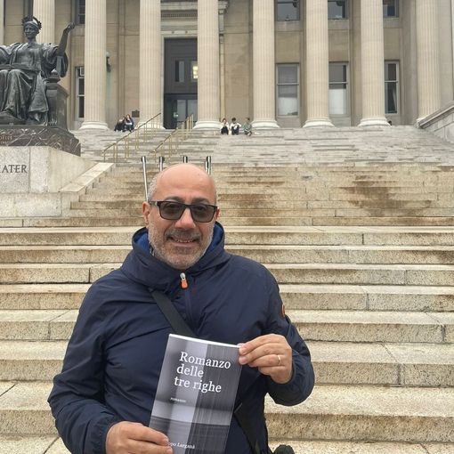 Larganà ritratto con una copia del suo romanzo d'esordio