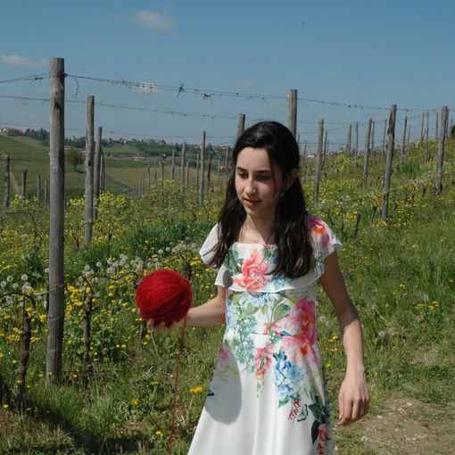 La giovane attrice Alice Borghetto con il gomitolo di lana rossa che scandisce il racconto
