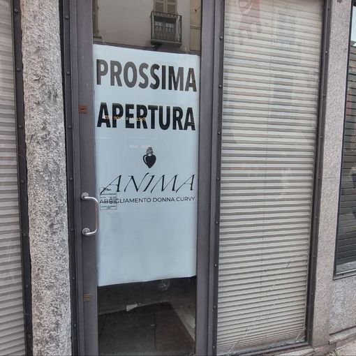 Cartello di prossima apertura di un negozio di abbigliamento in via Cavour