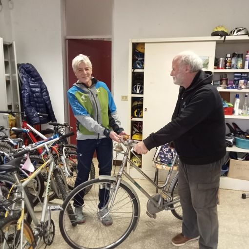 Pietro De Santis, presidente della CNA Pensionati Asti consegna le biciclette raccolte a Elena Dugono nel laboratorio della Città di Asti “La due ruote”