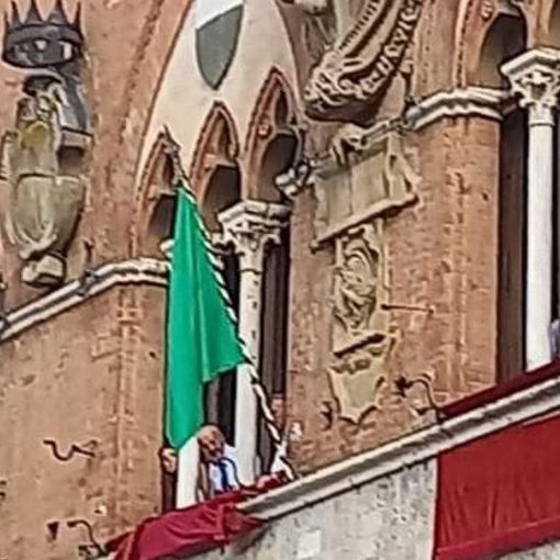 La bandiera verde esposta alla trifora del Palazzo Pubblico senese (foto riprodotta per gentile concessione del blog &quot;Brontolo dice la sua&quot;)