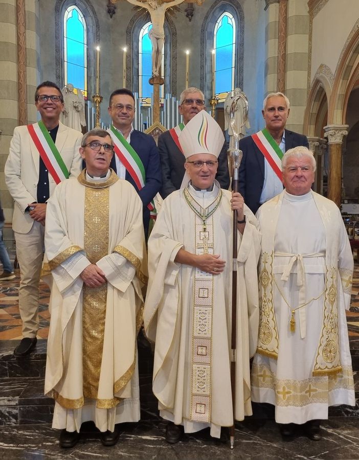 Don Marco Andina (a sinistra) con il vescovo Prastaro e il suo predecessore don Pierino Torchio. Alle loro spalle i sindaci dei quattro paesi