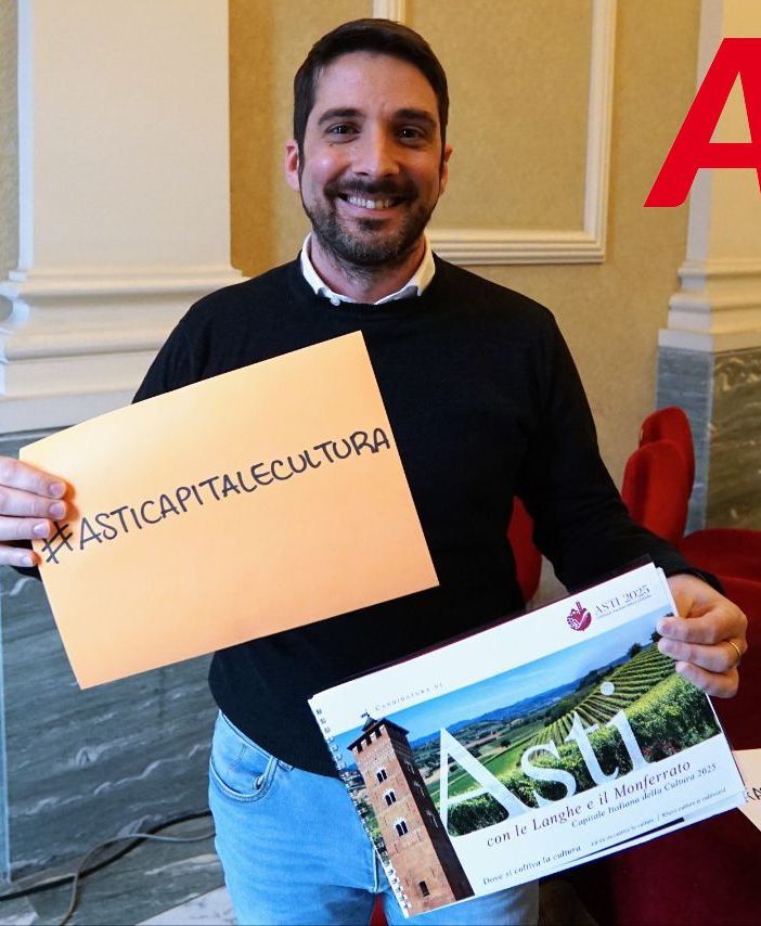 Nell'immagine (ph. Efrem Zanchettin), l'assessore Candelaresi ritratto mentre mostra uno degli hashtag associati alla candidatura astigiana