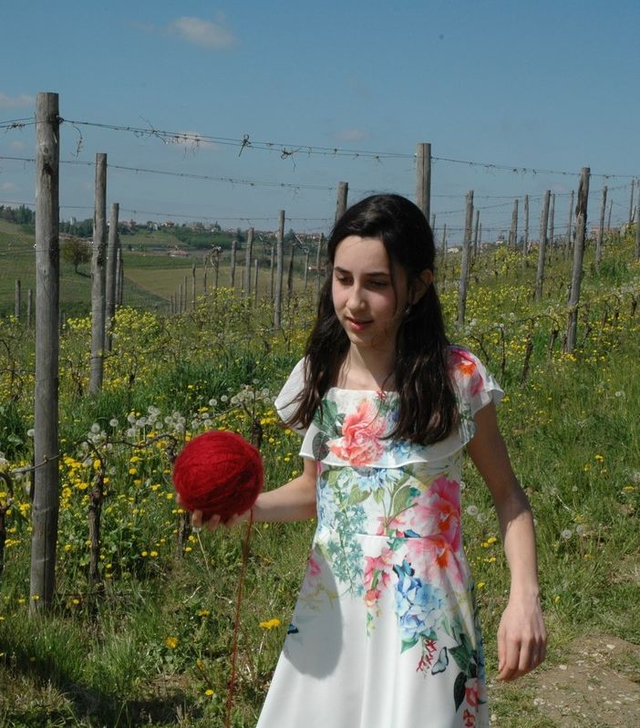 La giovane attrice Alice Borghetto con il gomitolo di lana rossa che scandisce il racconto