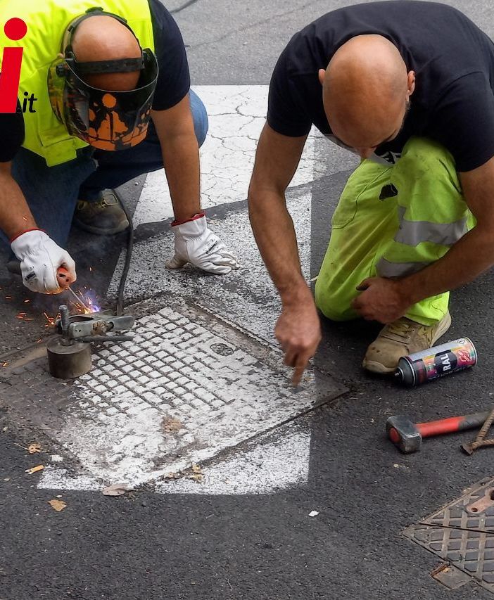 Operai impegnati nella piombatura di un tombino. Ph. Merfephoto - Efrem Zanchettin, come per le immagini a fine articolo inerenti l'allestimento della ruota panoramica