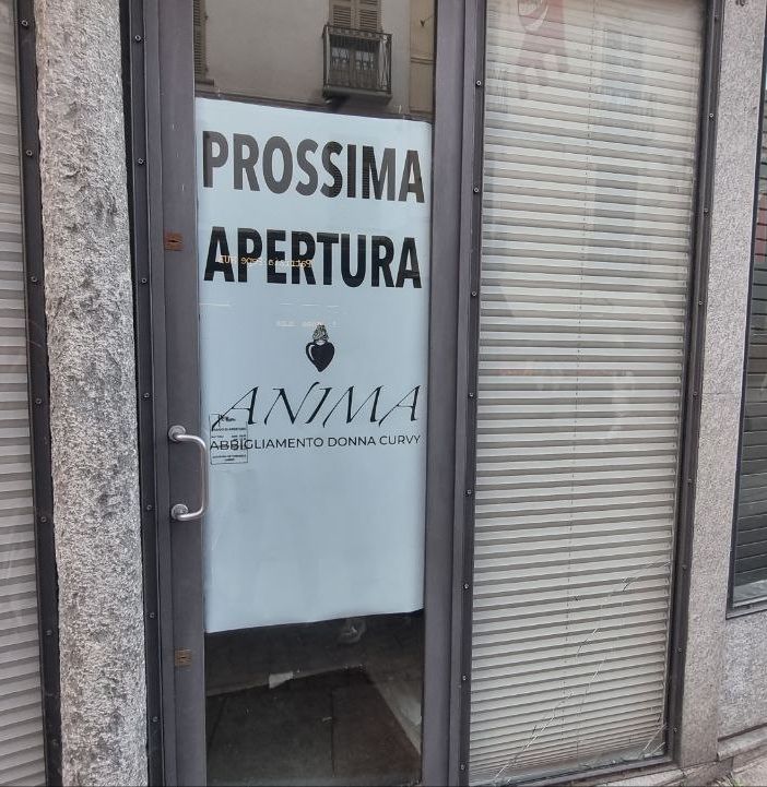Cartello di prossima apertura di un negozio di abbigliamento in via Cavour