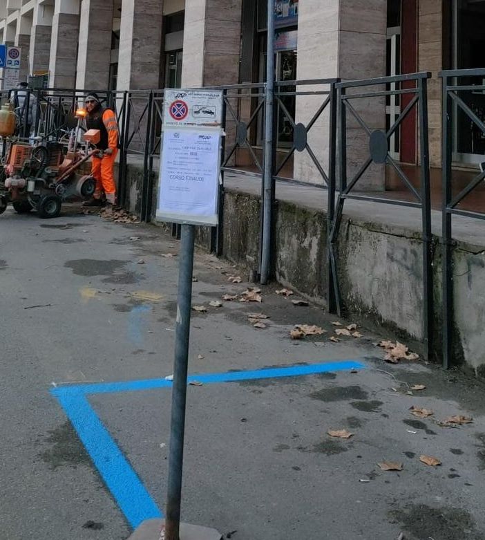 Operai impegnati nel tracciamento degli stalli blu