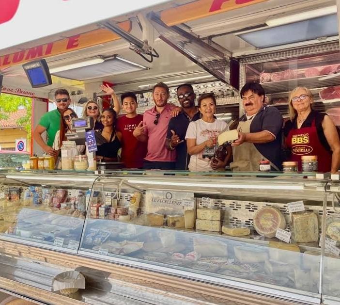 Turisti americani dietro al bancone di Michele al mercato di Buttigliera d'Asti