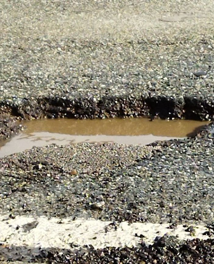 Una foto postata sui social che documenta le buche che si sono aperte sul fondo stradale