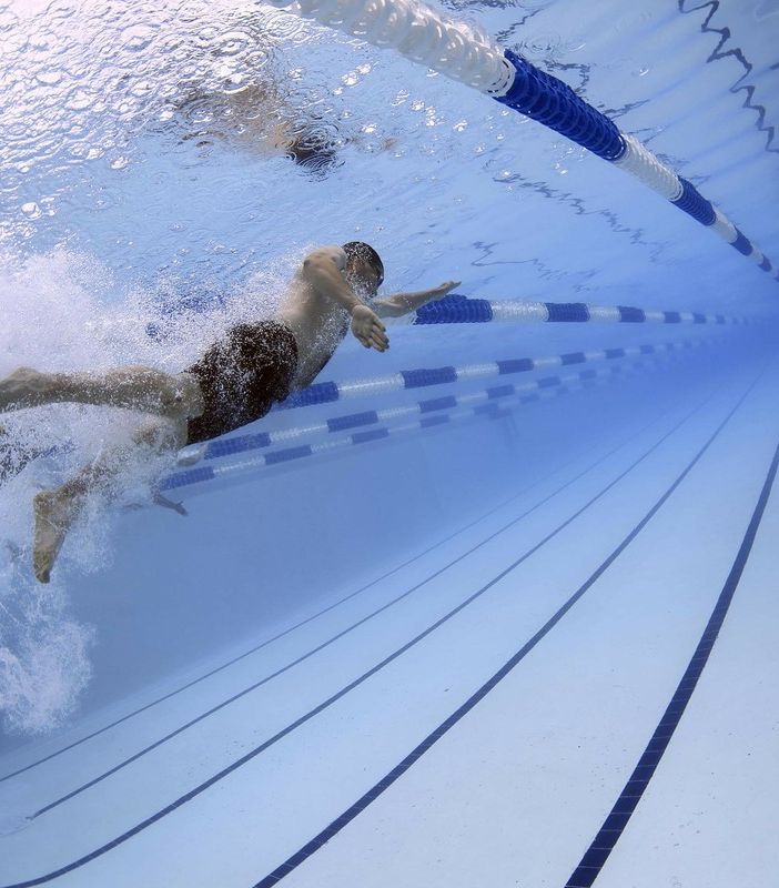 uomo in piscina mentre nuota