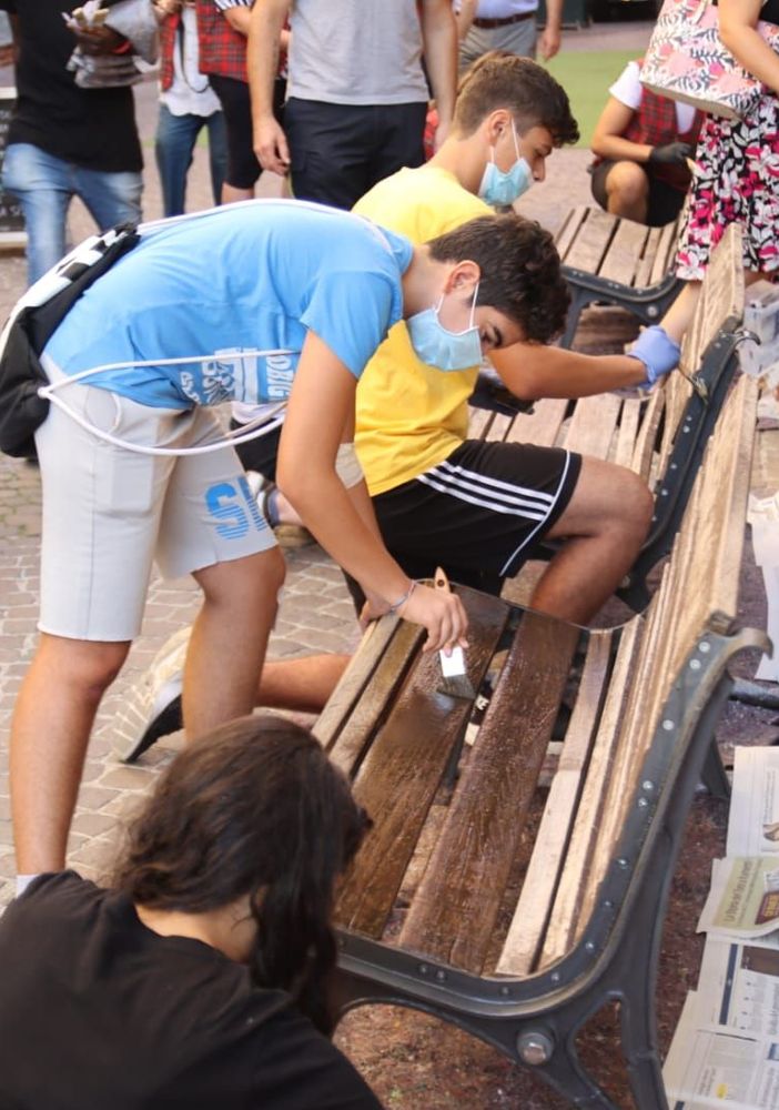 Nella foto, di Efrem Zanchettin-MerfePhoto, alcuni volontari di un'associazione impegnati a rimettere a nuovo una panchina