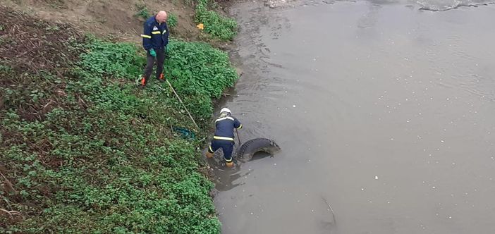 I volontari di protezione civile rimuovo copertone dal Borbore