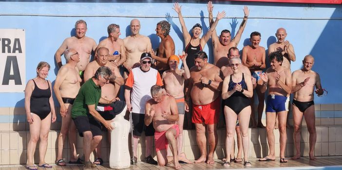 Gianni Caraffa con maglietta e cappellino festeggiato a bordo vasca