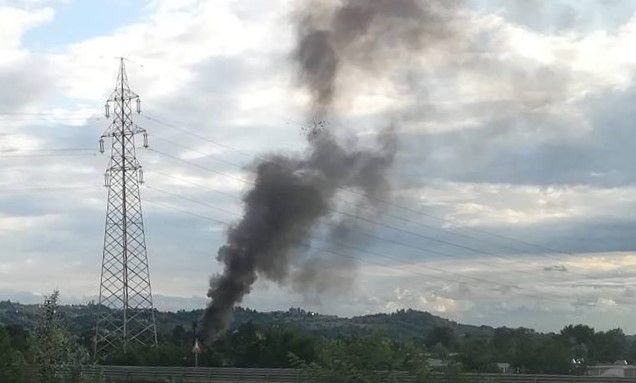 Il denso fumo nero generato da un precedente rogo di spazzatura