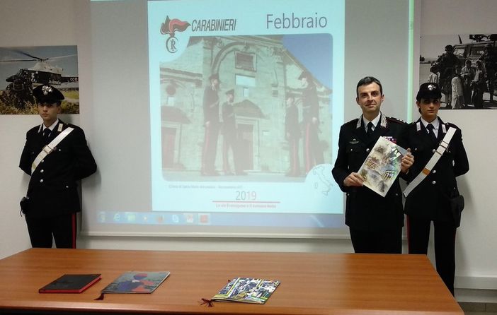 Il comandante Breda con il calendario 2019 e, sullo sfondo, la proiezione dello scatto inserito nella versione da tavolo