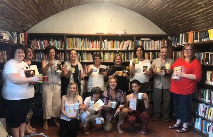 Il gruppo di partecipanti con libri e tazze in biblioteca Il gruppo di partecipanti con libri e tazze in biblioteca