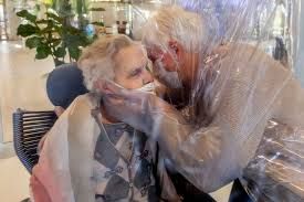 Anziani che si abbracciano in una stanza degli a bbracci