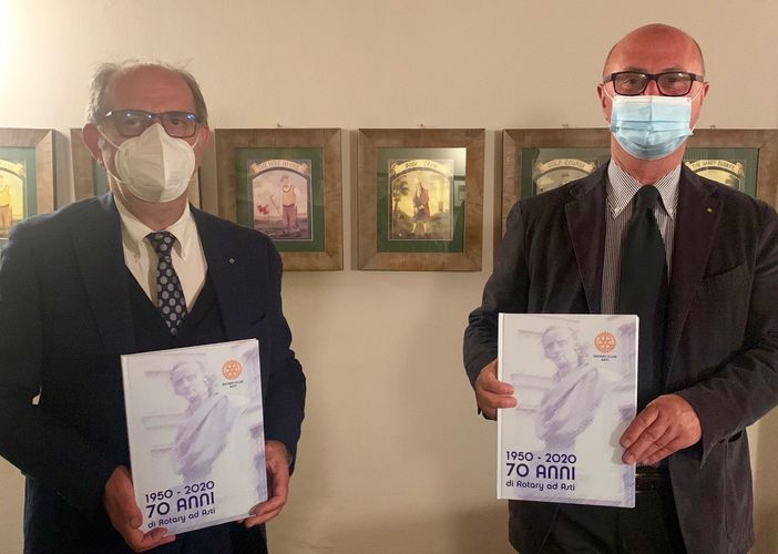 Il libro 1950-2020 70 anni di Rotary ad Asti nella mani del dirigente rotariano Giorgio Gianuzzi (a sinistra) autore del libro e Marco Stobbione presidente del Rotary Club di Asti.