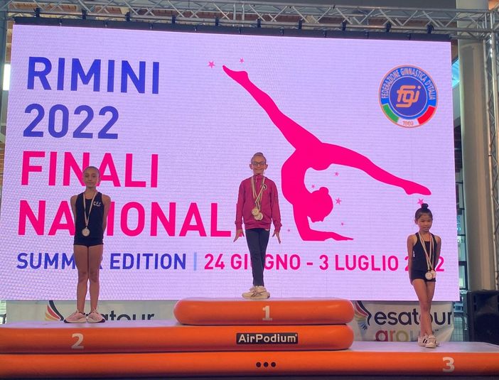 La giovanissima atleta sul gradino più alto del podio e, a fine articolo, ritratta con le tre medaglie vinte