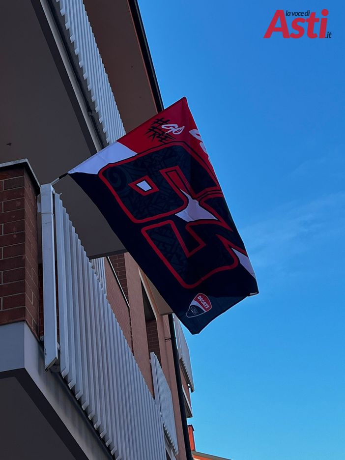 Anche ad Asti le bandiere rosso Ducati per festeggiare il grande Pecco Bagnaia, campione del mondo col numero 63 Anche ad Asti le bandiere rosso Ducati per festeggiare il grande Pecco Bagnaia, campione del mondo col numero 63