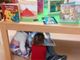 Alcuni bambini giocano sotto un tavolo della Biblioteca Monticone di Canelli