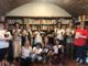 Il gruppo di partecipanti con libri e tazze in biblioteca