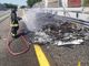 Un vigile del fuoco impegnato nello spegnimento degli ultimi tizzoni di un